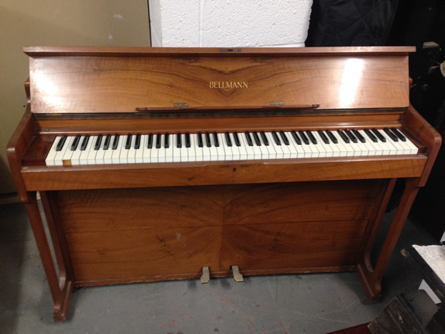 Small Bellmann piano in a Walnut satin cabinet.